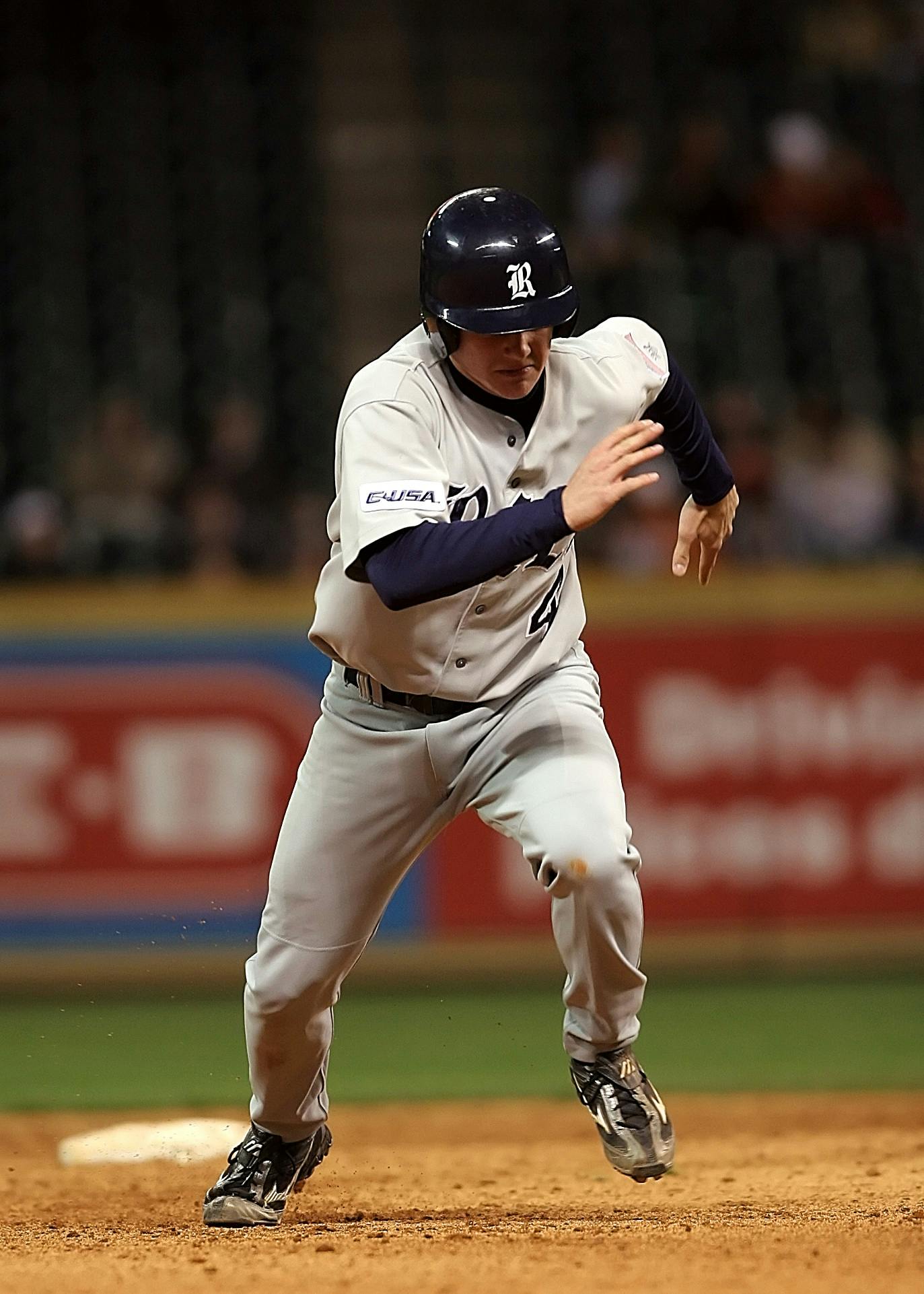 A baseball player in motion on the field, showcasing athleticism during a night game.